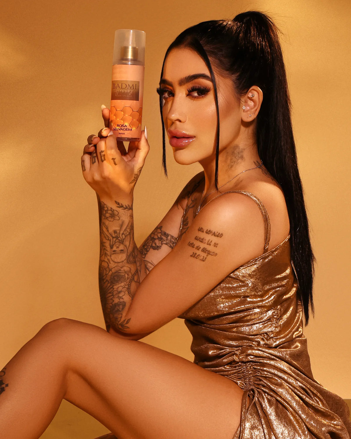 Modelo segurando o Body Splash BADMI Honey 200ml da Rosa Selvagem