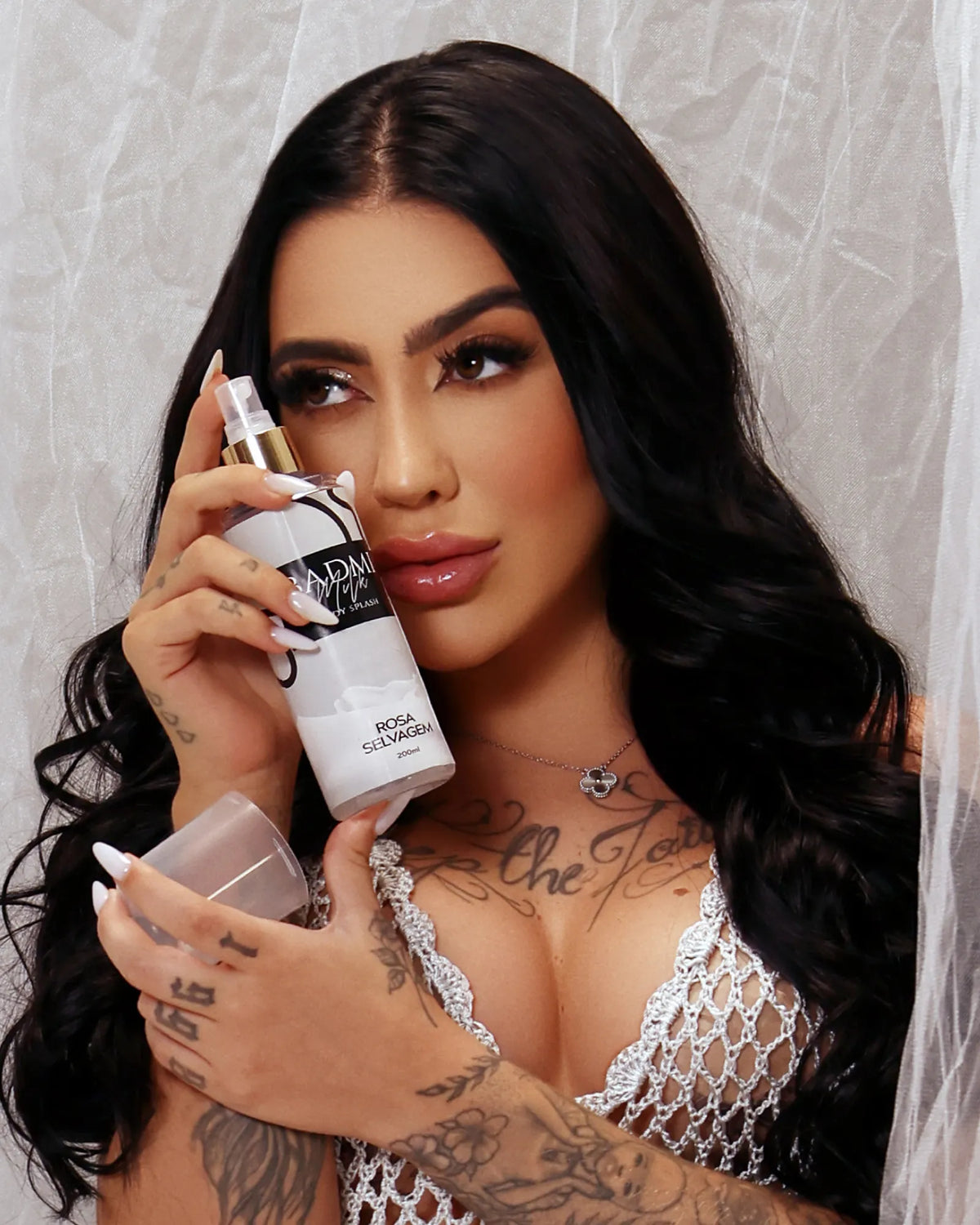 Modelo segurando o Body Splash BADMI Milk 200ml da Rosa Selvagem