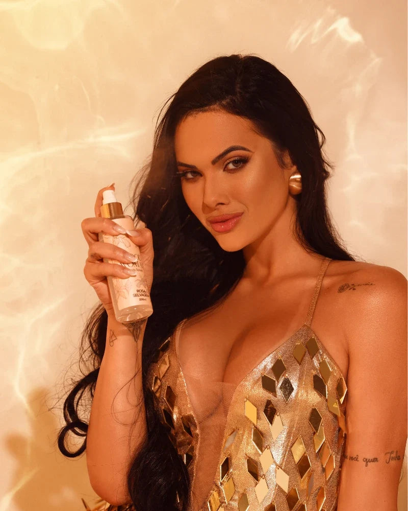 Modelo segurando o Body Splash Good Woman 200ml da Rosa Selvagem